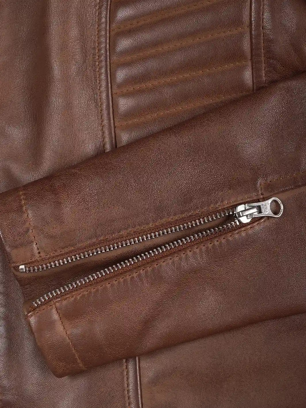 Close-up of a brown leather jacket with a zipper
